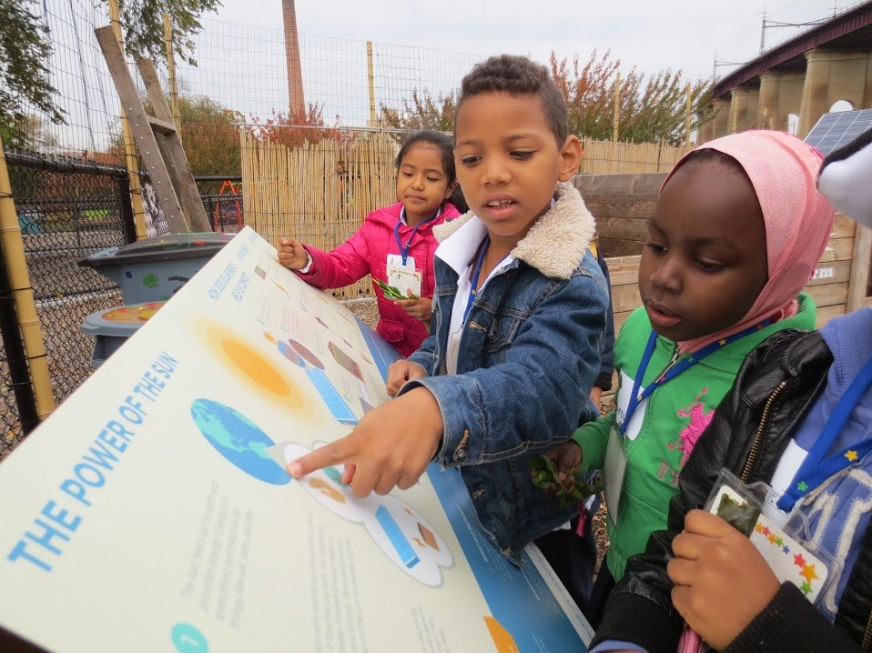 Children reading a Sun Club solar sign