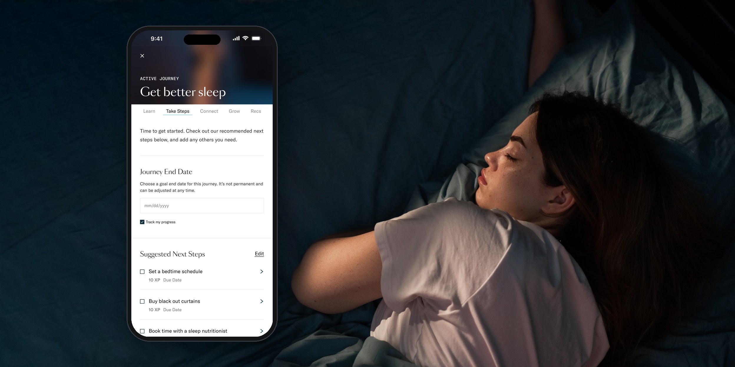 A woman asleep in bed beside a phone showing the Take steps tab of the Get better sleep journey